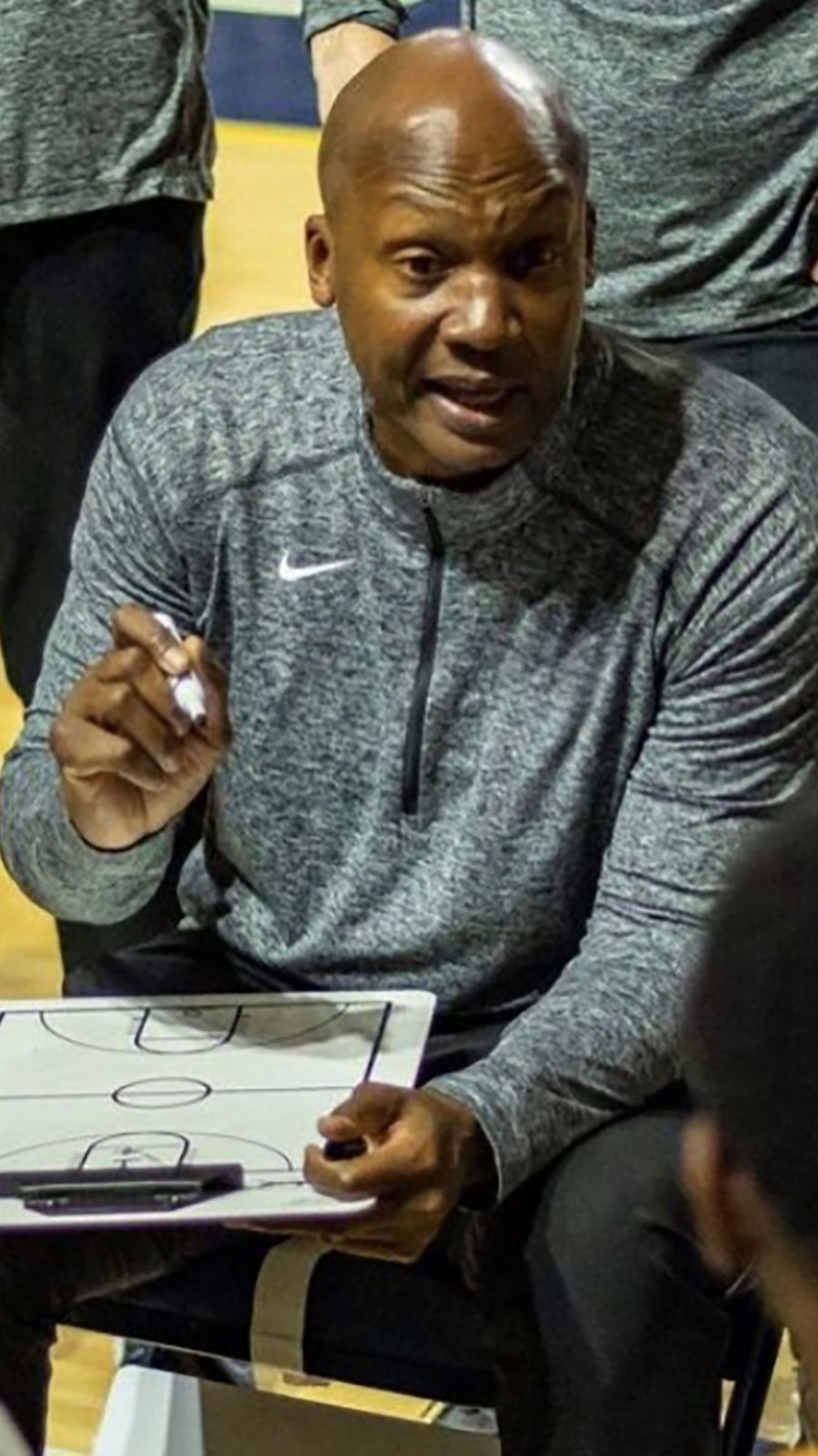 Coach Oliver courtside with the whiteboard at ETSU
